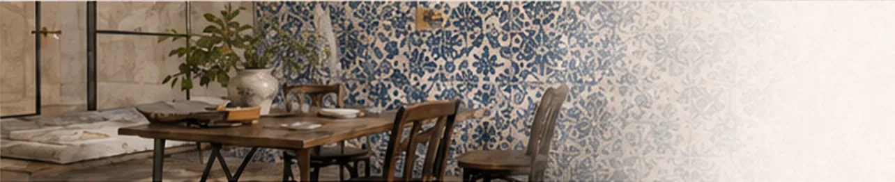 Dining room with a rustic wooden table and chairs in front of a wall of hand-painted blue and white Portuguese tiles