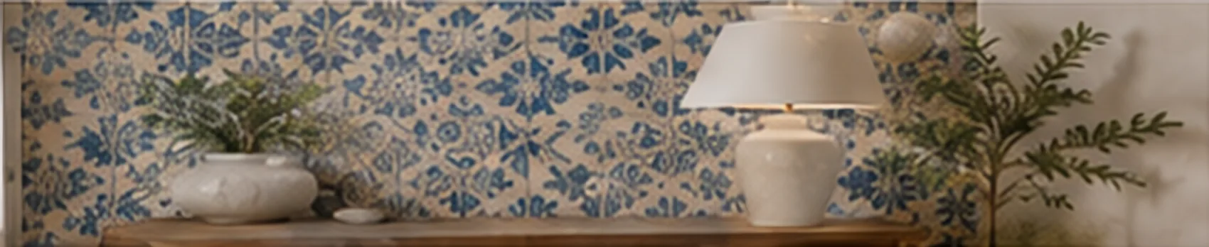 Feature wall of blue floral Portuguese tiles behind a console with a table lamp, vases and olive branches